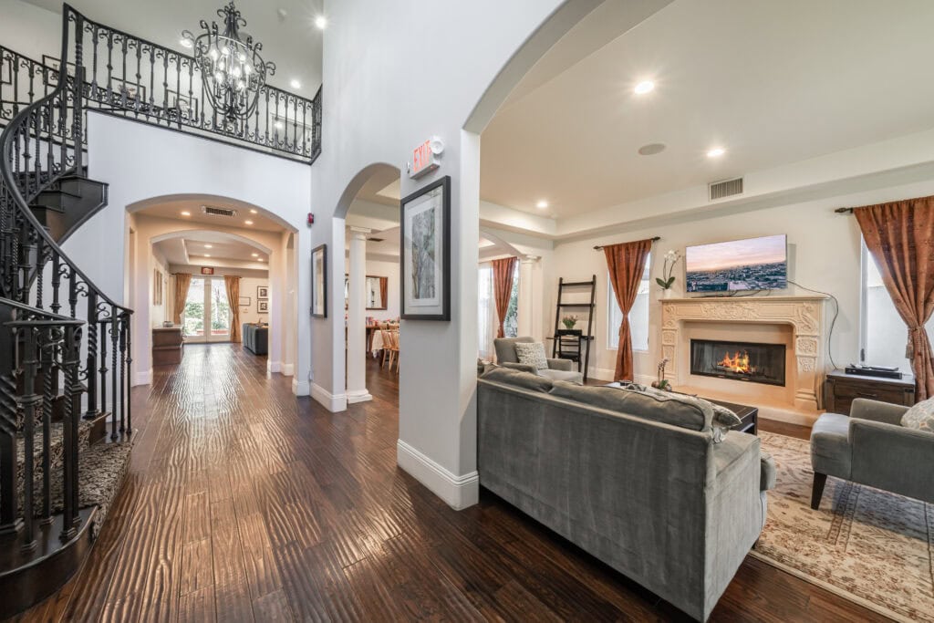 Open living area with a fireplace and staircase at Cliffside West LA's Overland residence.