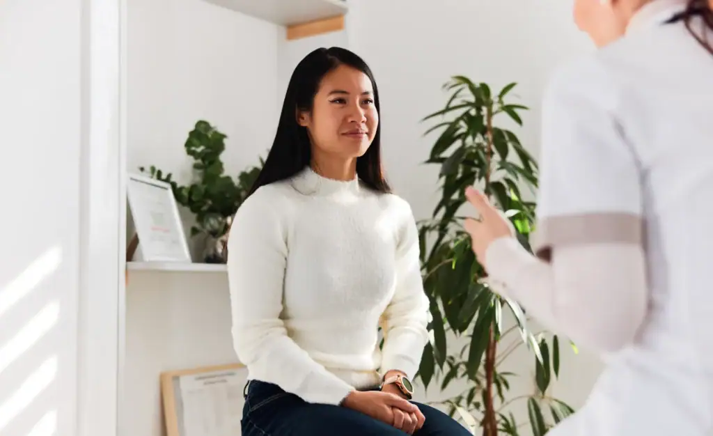 Young woman talking with a clinician during a consultation.